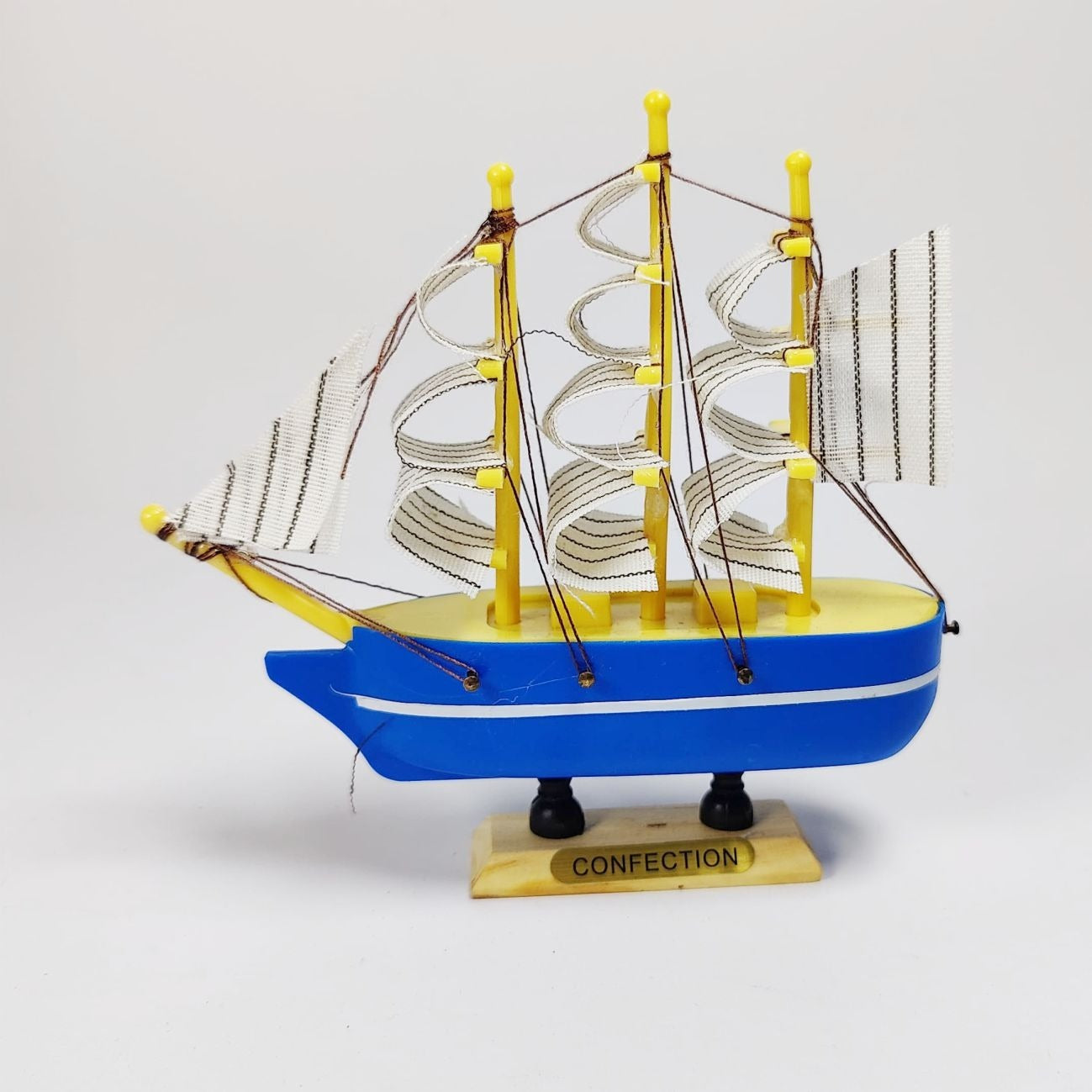 Model ship with blue hull and yellow superstructure on a white background