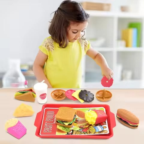 Child playing with a toy fast food set on a table.