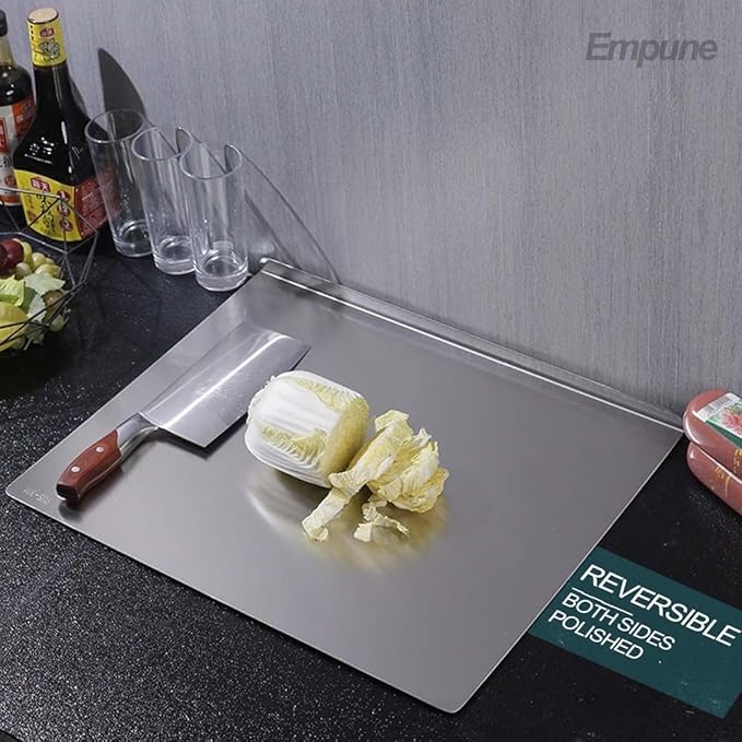 Stainless steel cutting board with a knife and cabbage on a kitchen counter, featuring the brand 'Empune'.