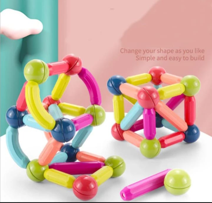 Colorful magnetic building toy set on a white surface with a pink and teal background.