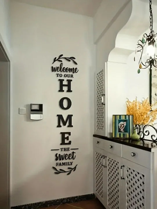 Decorative wall decal with 'Welcome to our Home, The Sweet Family' text in a modern kitchen.