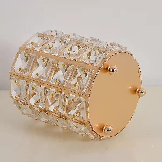 Decorative cylindrical object with crystal-like design and gold accents on a neutral background