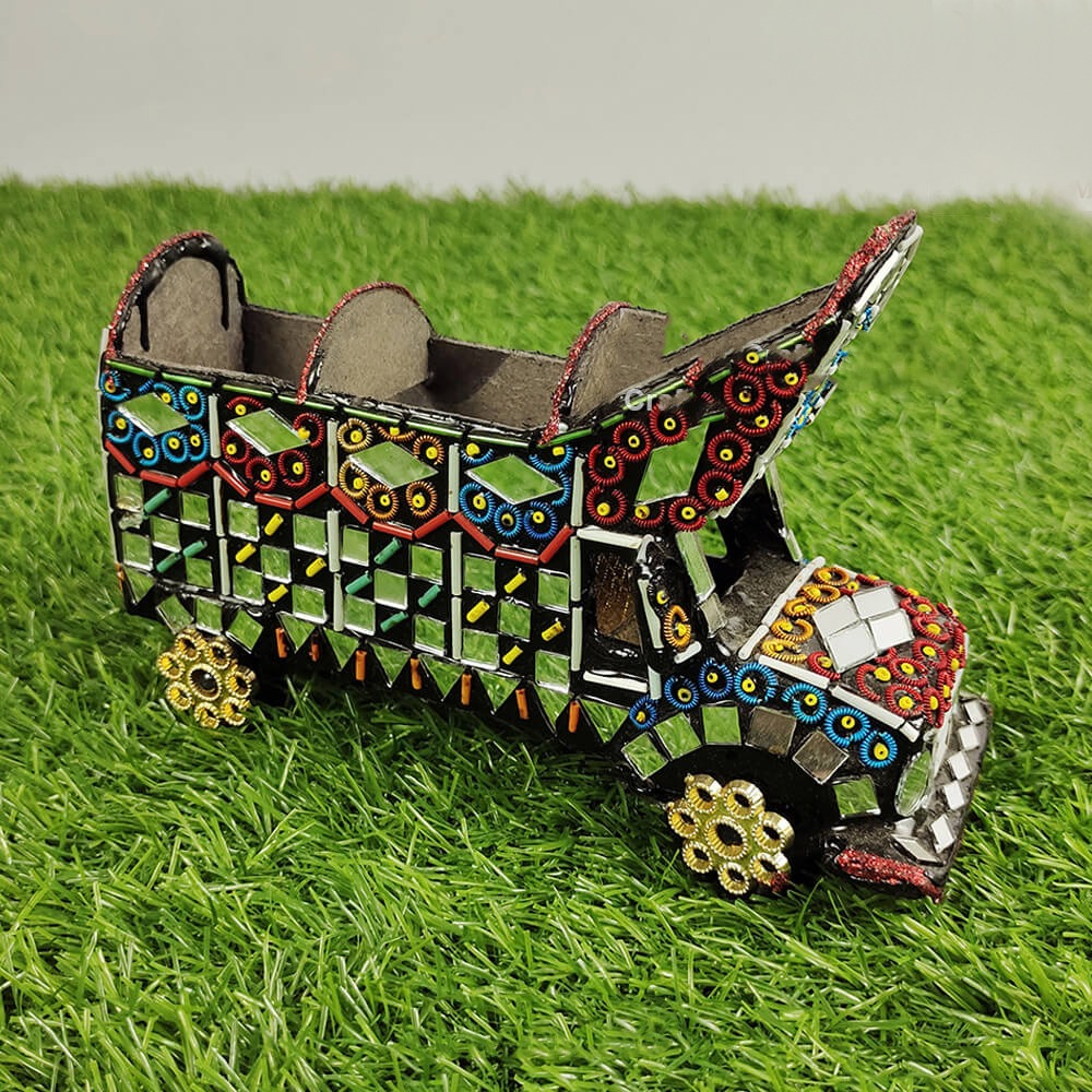 Decorative toy truck with mosaic design on a grassy background