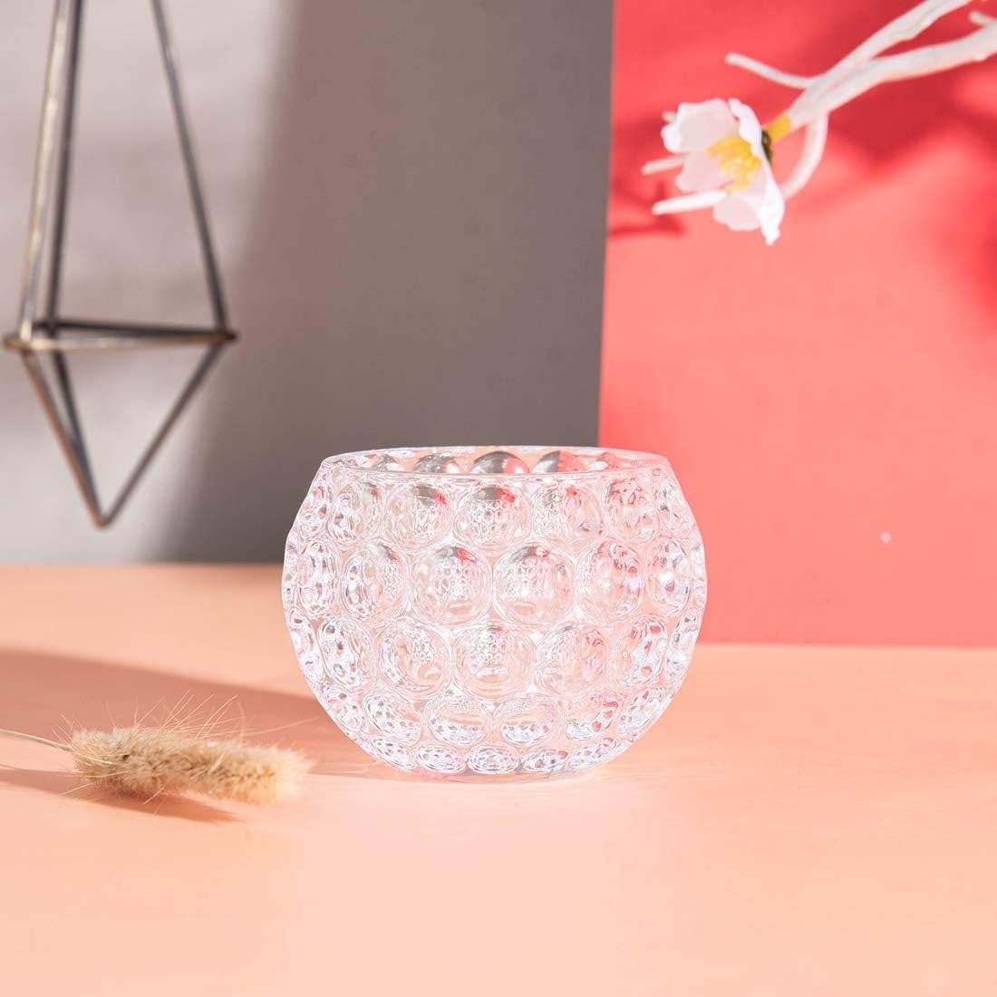 Decorative glass vase on a pink surface with a blurred background