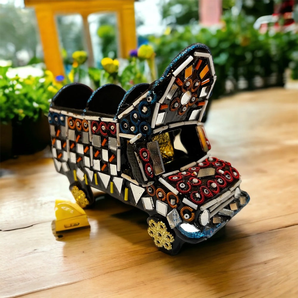 Decorative model of a truck with mosaic design on a wooden surface
