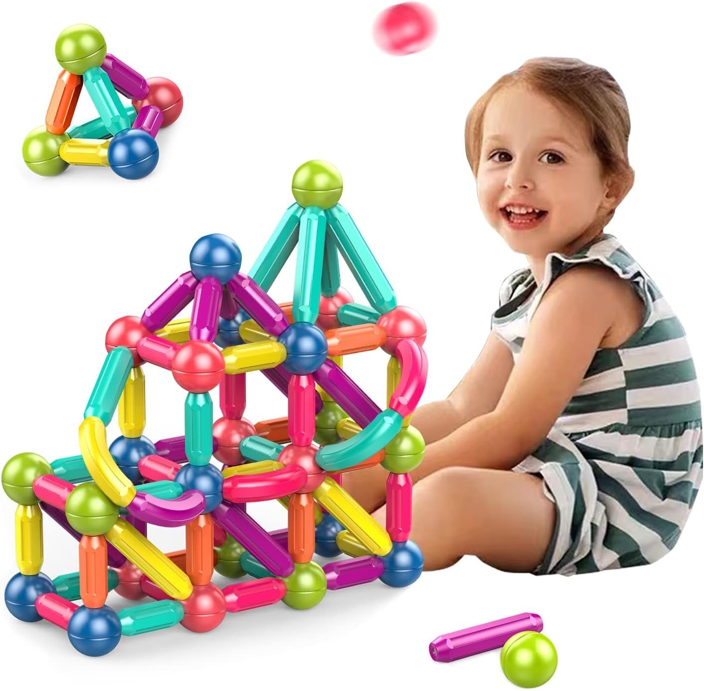 Child playing with colorful magnetic building blocks on a white background